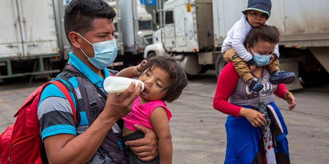 Honduran migrants walk to the border crossing after being transported in an army truck to El Florido, Guatemala, a border point between Guatemala and Honduras, Tuesday, Jan. 19, 2021. (AP Photo/Oliver de Ros) 03104