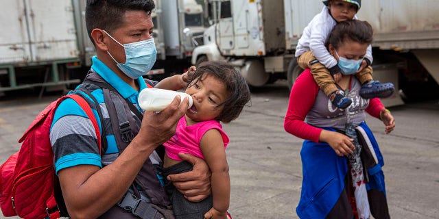 Honduran migrants walk to the border crossing after being transported in an army truck to El Florido, Guatemala, a border point between Guatemala and Honduras, Tuesday, Jan. 19, 2021. (AP Photo/Oliver de Ros) 03104