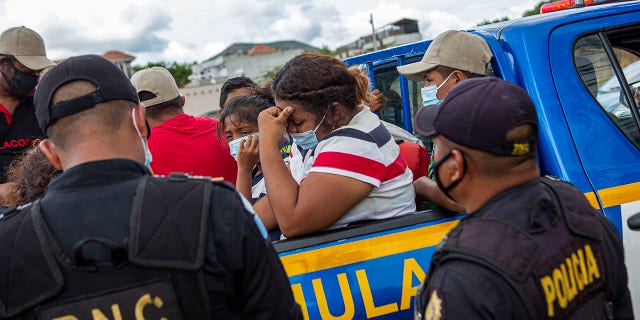 A Honduran migrant woman trying to reach the U.S. cries after she was detained in the Guatemalan department of Chiquimula, Tuesday, Jan. 19, 2021. (AP Photo/Oliver de Ros)