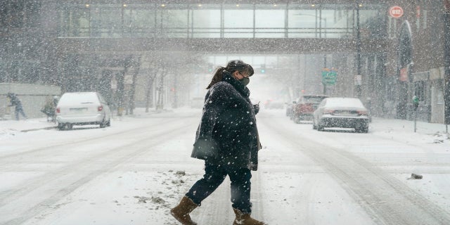 A pedestrian crosses a snow covered street on Monday in downtown Des Moines, Iowa. (AP)
