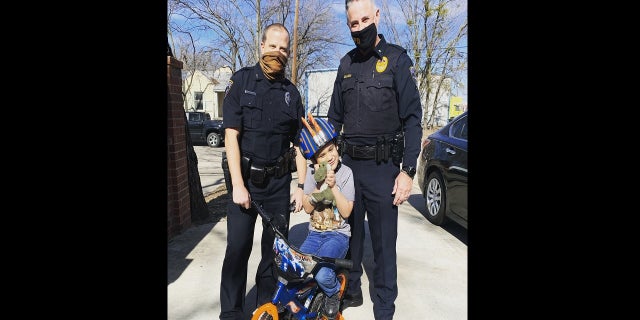 Detective Josh Smith, left, helped present a new bicycle to the child after his was destroyed. (Irving Police Department)