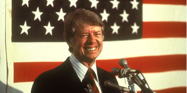 U.S. President Jimmy Carter smiling at a podium in front of an American flag, 1970s. (Photo by Hulton Archive/Getty Images)