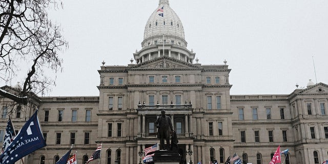 LANSING, MI - JANUARY 06: Supporters of President Donald Trump join in a mass prayer out front of the Michigan State Capitol Building to protest the certification of Joe Biden as the next president on January 6, 2021 in Lansing, Michigan. Trump supporters gathered at state capitals across the country to protest today's ratification of President-elect Joe Biden's Electoral College victory over President Trump in the 2020 election. (Photo by Matthew Hatcher/Getty Images)
