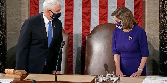 Speaker of the House Nancy Pelosi, D-Calif., and Vice President Mike Pence arrive to officiate as a joint session of the House and Senate convenes to count the Electoral College votes cast in November's election, at the Capitol in Washington, Wednesday, Jan. 6, 2021. (AP Photo/J. Scott Applewhite)