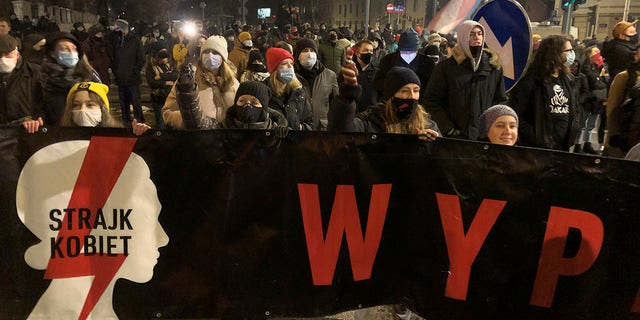People march near the ruling Law and Justice party headquarters in Warsaw, Poland Wednesday Jan. 27, 2021 to protest after the country's top court on Wednesday confirmed its highly divisive ruling that will further tighten the predominantly Catholic nation's strict anti-abortion law. (AP Photo/Czarek Sokolowski)