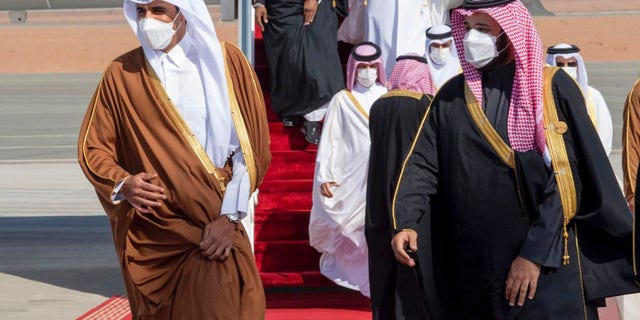在沙特皇家法院提供的这张照片中，沙特阿拉伯王储穆罕默德·本·萨勒曼（右）欢迎卡塔尔埃米尔谢赫·塔米姆·本·哈马德·阿勒萨尼抵达沙特阿拉伯，参加海湾合作委员会第41届峰会，2021年1月5日。
