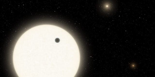 This illustration shows the planet KOI-5Ab transiting across the face of a Sun-like star, which is part of a triple-star system located 1,800 light-years away in the Cygnus constellation. (Credits: Caltech/R. Hurt Infrared Processing and Analysis Center, or IPAC.)