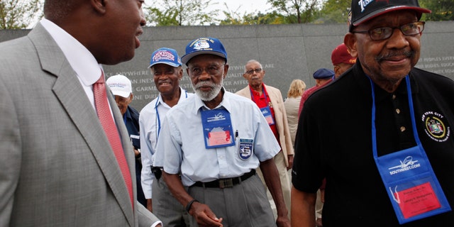 FILE - In this Aug. 3, 2011, file photo, Harry E. Johnson Sr., left, president &amp; CEO of the Martin Luther King Jr. Foundation, takes Tuskegee Airmen, including Theodore Lumpkin Jr., center, and Dabney Montgomery, right, on a tour of the Martin Luther King Jr. Memorial in Washington. Lumpkin has died from complications of the coronavirus, it was announced Friday, Jan. 8, 2021. Lumpkin was just days short of his 101st birthday. Lumpkin, a Los Angeles native, died Dec. 26, according to a statement from Los Angeles City College, which he attended from 1938 to 1940. (AP Photo/Jacquelyn Martin, File)