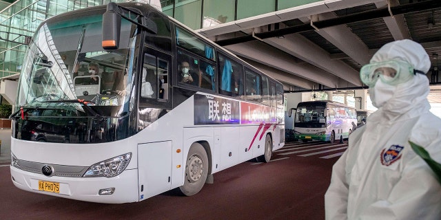 Um ônibus que transportava membros de uma equipe da OMS que investigava as origens da pandemia COVID-19 deixa o aeroporto após sua chegada a uma seção fechada na área de desembarque internacional do aeroporto de Wuhan em 14 de janeiro de 2021. (Foto de Nicholas Asfoury / AFP ) (Foto de Nicolas Asfoury / Agência) Imprensa francesa (via Getty Images)