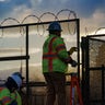 Workers install razor wire atop fencing around the U.S. Capitol perimeter at sunset, in Washington, Monday, Jan. 18, 2021.  (AP Photo/J. Scott Applewhite)