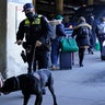 An Amtrak K9 officer and his dog check passengers before they board an Amtrak train before its departure from Union Station as security is heightened ahead of President-elect Joe Biden's inauguration ceremony, Tuesday, Jan. 19, 2021, in Washington.
