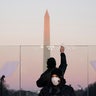 Staff members clean the glass on a protective shield and the podium before President-elect Joe Biden speaks during a COVID-19 memorial, with lights placed around the Lincoln Memorial Reflecting Pool, Tuesday, Jan. 19, 2021, in Washington.