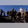 Members of the National Guard walk past the Dome of the Capitol Building on Capitol Hill in Washington, Thursday, Jan. 14, 2021. (AP Photo/Andrew Harnik)