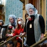 People shelter in the House gallery as protesters try to break into the House Chamber at the U.S. Capitol on Wednesday, Jan. 6, 2021, in Washington.