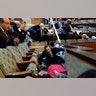 People shelter in the House gallery as protesters try to break into the House Chamber at the U.S. Capitol on Wednesday, Jan. 6, 2021, in Washington.