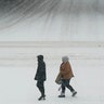 Pedestrians cross a snow-covered street, Monday, Jan. 25, 2021, in downtown Des Moines, Iowa. A major winter storm is expected to blanket a large swath of the middle of the country with snow Monday and disrupt travel as more than a foot of snow falls in some areas.