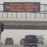 Traffic passes a sign warning of a winter storm, Monday, Jan. 25, 2021, in Des Moines, Iowa. A major winter storm is expected to blanket a large swath of the middle of the country with snow Monday and disrupt travel as more than a foot of snow falls in some areas.