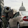 A National Guardsman checks a vehicle at a road block outside the Capitol as security is ramped ahead of President-elect Joe Biden's inauguration ceremony Monday, Jan. 18, 2021, in Washington.