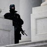 An armed U.S. Capitol Police officer looks out from the East side of the Capitol, during a rehearsal for President-elect Joe Biden's inauguration ceremony, at the Capitol in Washington, Monday, Jan. 18, 2021.