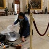 Rep. Andy Kim, D-N.J., cleans up debris and personal belongings strewn across the floor of the Rotunda in the early morning hours of Thursday, Jan. 7, 2021, after protesters stormed the Capitol in Washington, on Wednesday