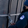 A U.S. Capitol Police checks a lock on a fence installed along the perimeter of the Capitol building on Capitol Hill in Washington, Thursday, Jan. 14, 2021.