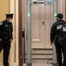 U.S. Capitol Police survey the corridor around the House of Representatives chamber after enhanced security protocols were enacted, including metal detectors for lawmakers, after a mob loyal to President Donald Trump stormed the Capitol, in Washington, Tuesday, Jan. 12, 2021.