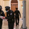 U.S. Capitol Police survey the corridor around the House of Representatives chamber after enhanced security protocols were enacted, including metal detectors for lawmakers, after a mob loyal to President Donald Trump stormed the Capitol, in Washington, Tuesday, Jan. 12, 2021.