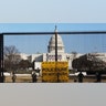 National guards are seen Wednesday, Jan. 13, 2021 on a fence that was erected to reinforce security at the Capitol in Washington. (AP Photo/Shafkat Anowar)