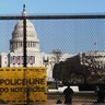 National guards are seen Wednesday, Jan. 13, 2021 on a fence that was erected to reinforce security at the Capitol in Washington. (AP Photo/Shafkat Anowar)