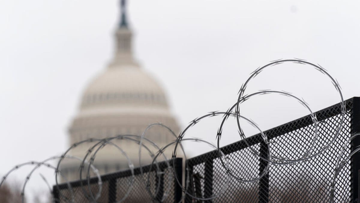 The U.S. Capitol is seen behind the razor fence around the U.S. Capitol, Thursday, Feb. 18, 2021.