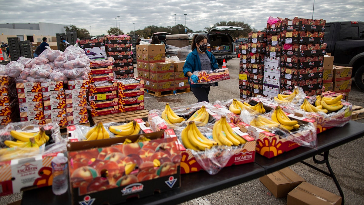 A volunteer carries food to be distributed during the Neighborhood Super Site food distribution event 