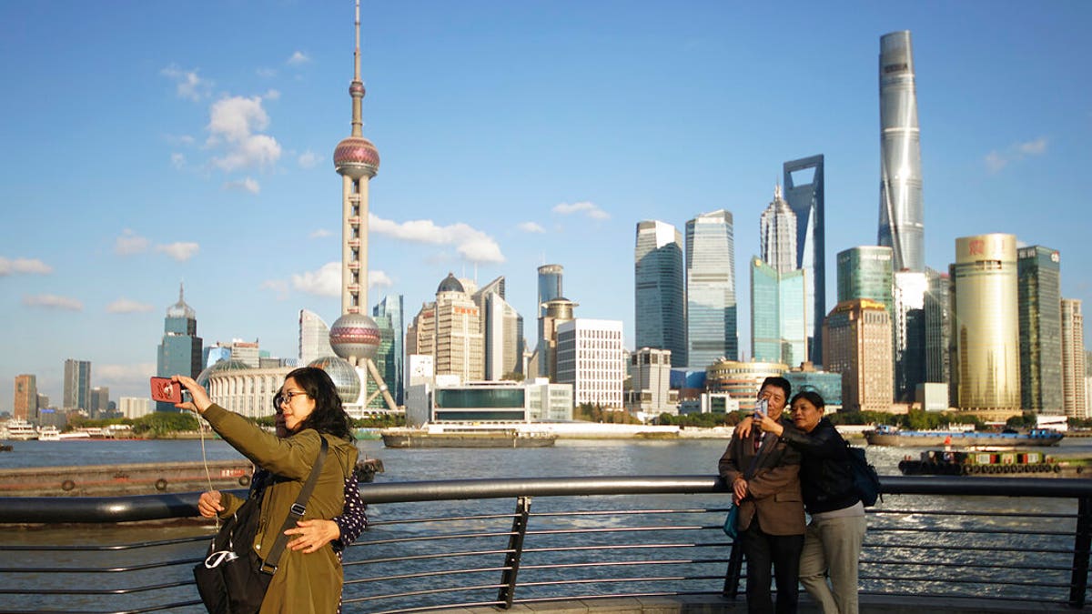 FILE: People take selfies of the Pudong skyline as they stand on the Bund in Shanghai, China. 