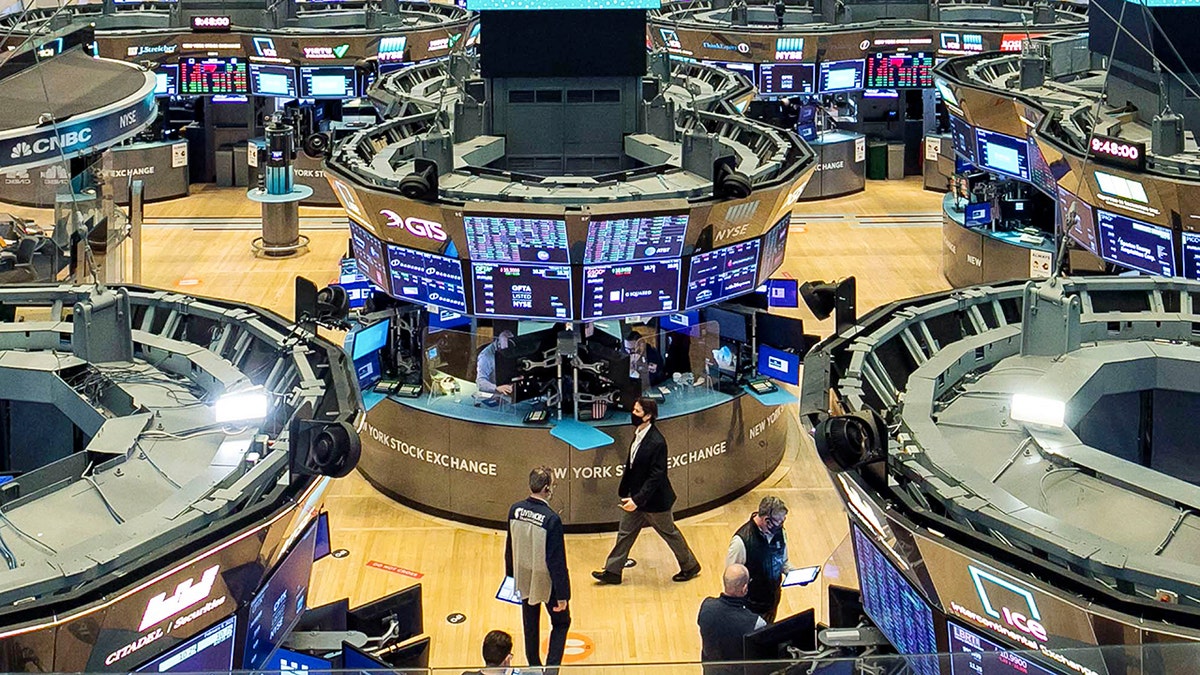 In this photo provided by the New York Stock Exchange, traders work on the floor, Tuesday, Feb. 9, 2021. Stocks were slightly lower in early trading on Tuesday, after the major stock market indexes hit record highs the day before. Investors continue to keep their eyes on Washington, where it appears Democrats plan to move ahead without Republican help on a major stimulus bill for the economy. (Courtney Crow/New York Stock Exchange via AP)