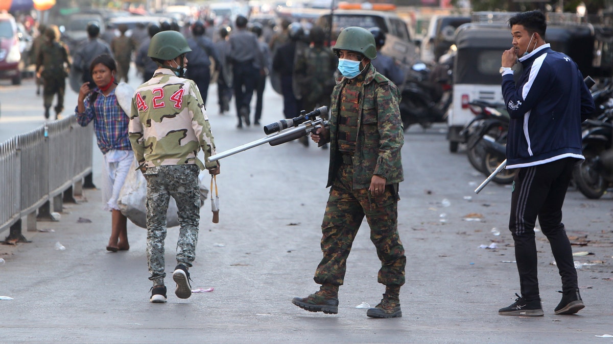 A soldier holds a long firearm during a crackdown on anti-coup protesters holding a rally in front of the Myanmar Economic Bank in Mandalay, Burma on Monday, Feb. 15, 2021.? (AP Photo)