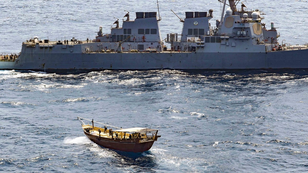 In this Friday, Feb. 12, 2021 photo released by the U.S. Navy, the guided-missile destroyer USS Winston S. Churchill boarded a stateless dhow off the coast of Somalia and interdicted an illicit shipment of weapons and weapon components. The U.S. Navy said on Tuesday, Feb. 16 that it seized a large cache of weapons, including Kalashnikov-style rifles and rocket-propelled grenade launchers, being smuggled by ships off the coast of Somalia. (Mass Communication Specialist 3rd Class Louis Thompson Staats IV/U.S. Navy via AP)