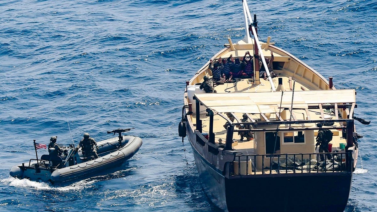 In this Friday, Feb. 12, 2021 photo released by the U.S. Navy, the guided-missile destroyer USS Winston S. Churchill boarded a stateless dhow off the coast of Somalia and interdicted an illicit shipment of weapons and weapon components. The U.S. Navy said on Tuesday, Feb. 16, that it seized a large cache of weapons, including Kalashnikov-style rifles and rocket-propelled grenade launchers, being smuggled by ships off the coast of Somalia. (Mass Communication Specialist 3rd Class Louis Thompson Staats IV/U.S. Navy via AP)