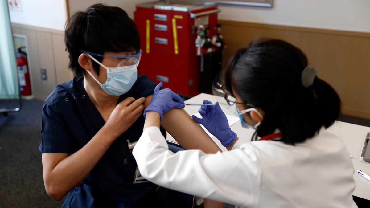 A medical worker receives a dose of COVID-19 vaccine at Tokyo Medical Center in Tokyo Wednesday, Feb. 17, 2021. (Behrouz Mehri/Pool Photo via AP)