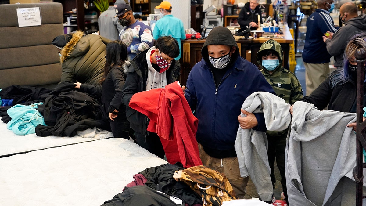 People select shirts and sweatshirts being given away at a Gallery Furniture store after the owner opened his business as a shelter for those without power at their homes in Houston, Feb. 16, 2021. (Associated Press)