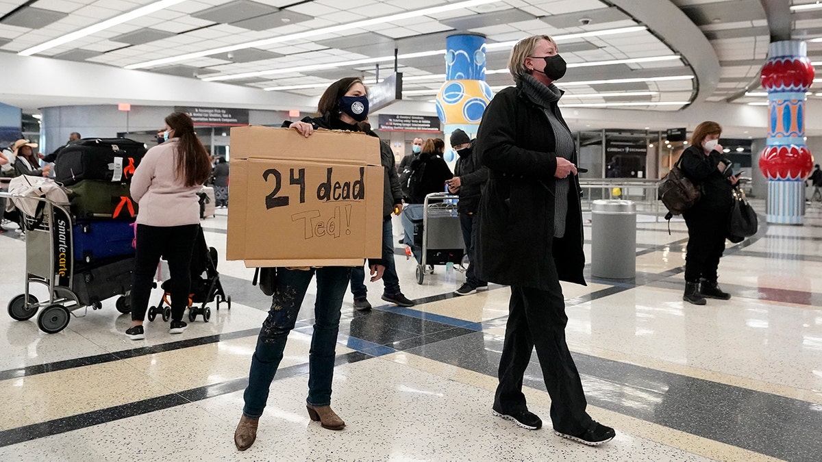 Mary Kay Hoffman, left, and Cindy Durham, right, wait for the arrival of Sen. Ted Cruz, R-Texas, at the international arrivals terminal at George Bush Intercontinental Airport Thursday, Feb. 18, 2021, in Houston. (AP Photo/David J. Phillip)