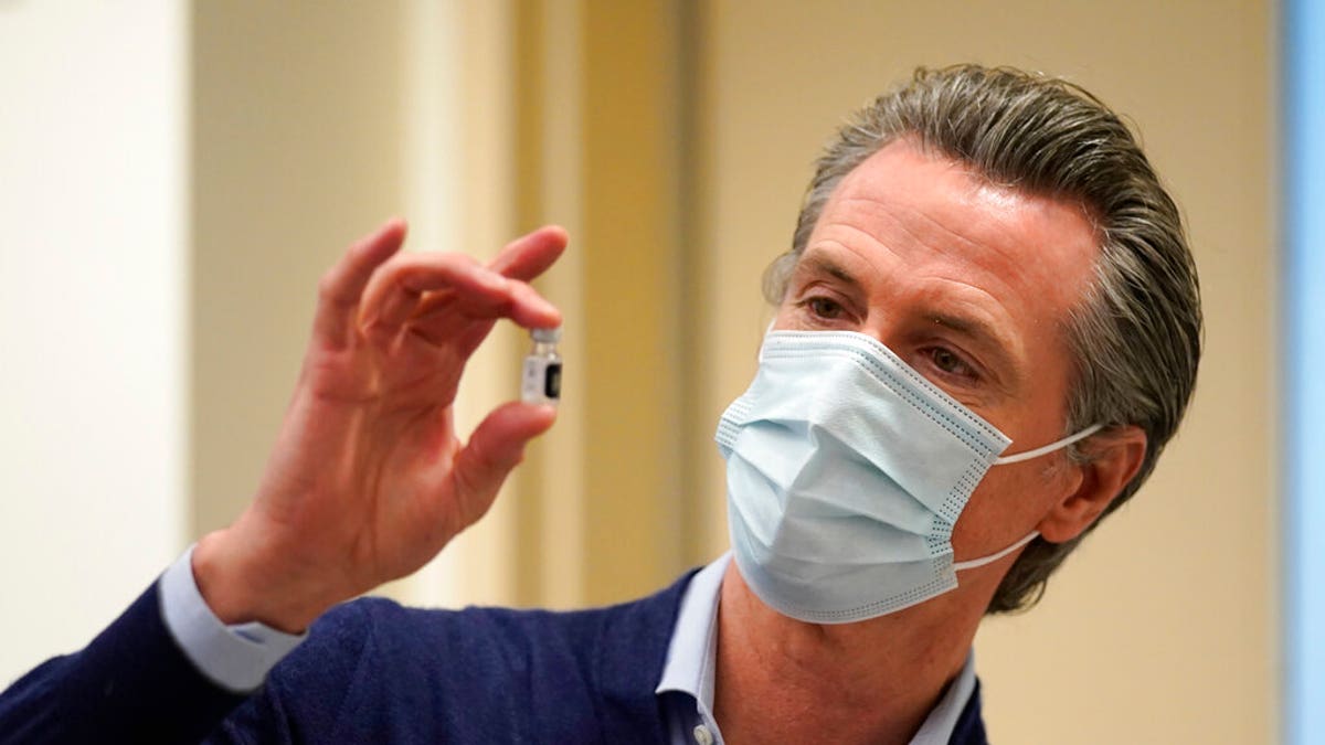FILE: California Gov. Gavin Newsom holds up a vial of the Pfizer-BioNTech COVID-19 vaccine at Kaiser Permanente Los Angeles Medical Center in Los Angeles. 