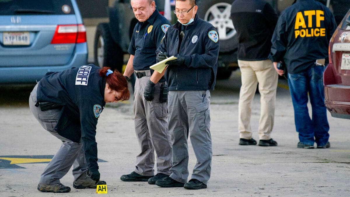 Investigators look at evidence at the scene of a multiple fatality shooting at the Jefferson Gun Outlet in Metairie, La., on Saturday, Feb. 20, 2021. (Associated Press)