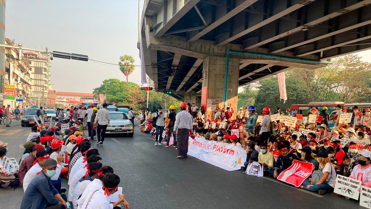 Anti-coup protesters gather under an elevated roadway just outside the Hledan Centre in Yangon, Burma Monday, Feb. 22, 2021. A call for a Monday general strike by demonstrators in Burma protesting the military's seizure of power has been met by the ruling junta with a thinly veiled threat to use lethal force, raising the possibility of major clashes. (AP Photos)