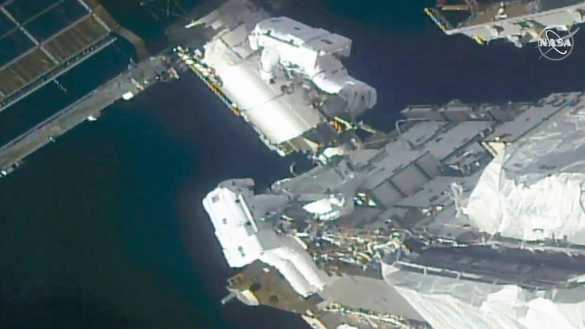 In this image taken from NASA video, NASA astronauts Kate Rubins, top, and Victor Glover work outside the International Space Station Sunday, Feb. 28, 2021. The spacewalking astronauts ventured out Sunday to install support frames for new, high-efficiency solar panels arriving at the International Space Station later this year. (NASA via AP)