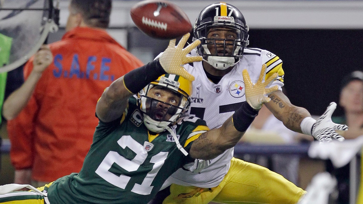 FILE - In this Feb. 6, 2011, file photo, Green Bay Packers' Charles Woodson (21) defends on a pass intended for Pittsburgh Steelers' Mike Wallace during the first half of the NFL football Super Bowl XLV football game in Arlington, Texas, in this Sunday, Feb. 6, 2011, file photo. (AP Photo/Dave Martin, File)