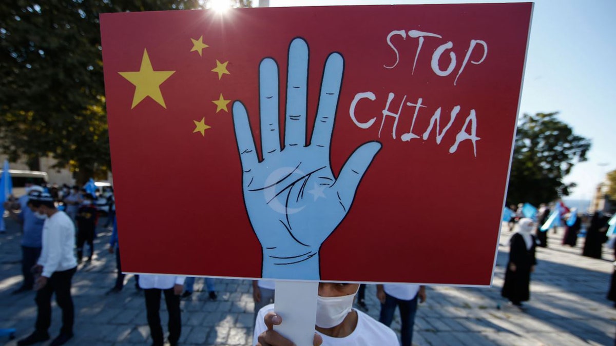 A protester from the Uighur community in Turkey holds an anti-China placard during a protest in Istanbul on Oct. 1, 2020, against what they allege is oppression by the Chinese government to Muslim Uighurs in the far-western Xinjiang province. (AP Photo/Emrah Gurel, File)