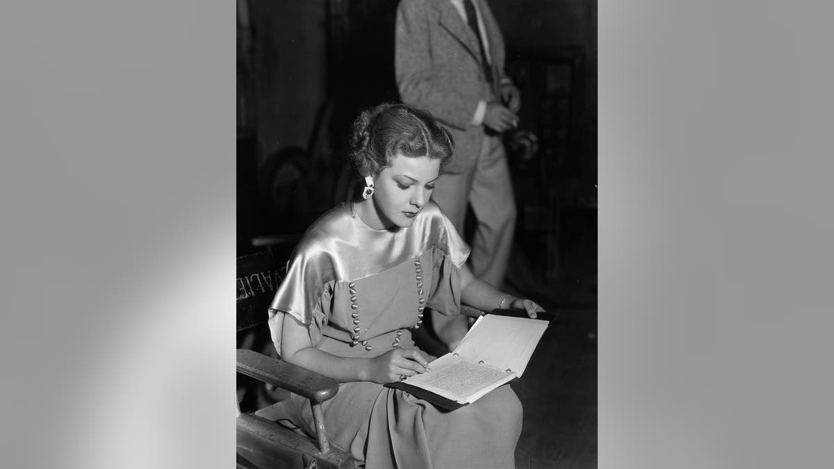 Actress Elissa Landi concentrates on a bit of writing between takes of the Paramount film 'The Great Flirtation', directed by Ralph Murphy.