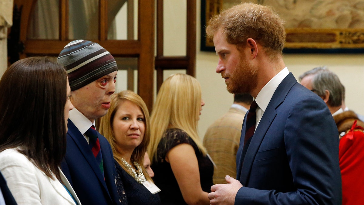 Prince Harry speaks to Martyn Compton, a former British soldier from the Household Cavalry Regiment who suffered his injuries after an RPG set his vehicle alight in Afghanistan, at the Lord Mayor's Big Curry Lunch in aid of the ABF The Soldiers Charity at The Guildhall on April 7, 2016, in London, England.