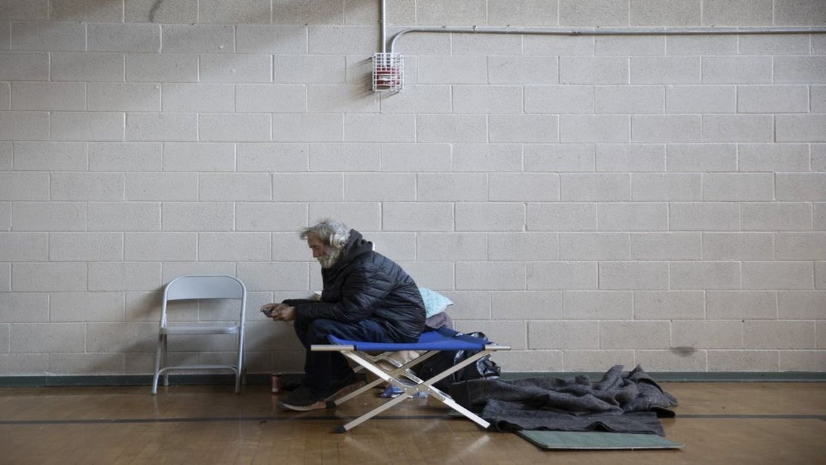 Allan Woodson rests in a warming shelter at St. Martin's Lutheran Church on West 15th Street in downtown Austin, Texas, Thursday, Feb. 18, 2021. Church members opened the shelter Sunday and have been sheltering and feeding more than 20 homeless people during the winter storm. (Jay Janner/Austin American-Statesman via AP)