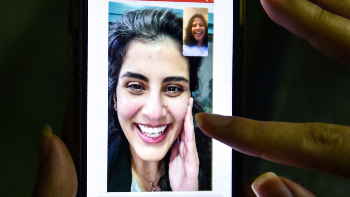 This picture taken February 10, 2021 in Saudi Arabia's capital Riyadh shows a woman viewing a tweet posted by the sister of Saudi activist Loujain al-Hathloul, Lina, showing a screenshot of them having a video call following Hathloul's release after nearly three years in detention. (Photo by Fayez Nureldine / AFP) (Photo by FAYEZ NURELDINE/AFP via Getty Images)