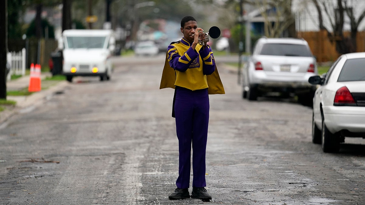Elvin King III, a senior at Warren Easton High and member of their marching band which was slated to perform in a now-canceled parade, poses for a portrait in front of his home in New Orleans. (AP Photo/Gerald Herbert)